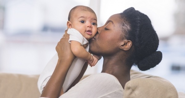 American mother gently holds her infant daughter